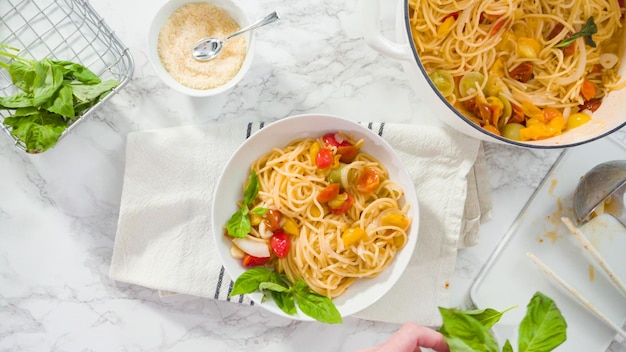 Plat leggen. Stap voor stap. Een eenpanspasta op een wit pastabord serveren.