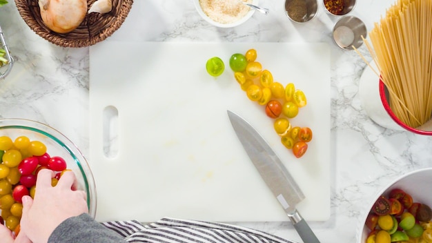 Plat leggen. Stap voor stap. Groenten snijden op een witte snijplank om een eenpans pastarecept te maken.