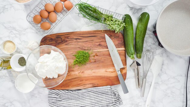 Plat leggen. stap voor stap. ingrediënten mengen in een mengkom om courgettecakes te maken.