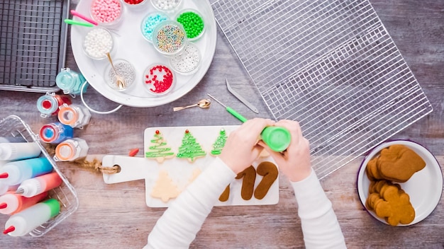 Plat leggen. Stap voor stap. Peperkoek en suikerkoekjes versieren met royal icing voor Kerstmis.