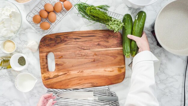 Plat leggen. Stap voor stap. Snij-ingrediënten voor het maken van courgettecakes met kruidenzure room.