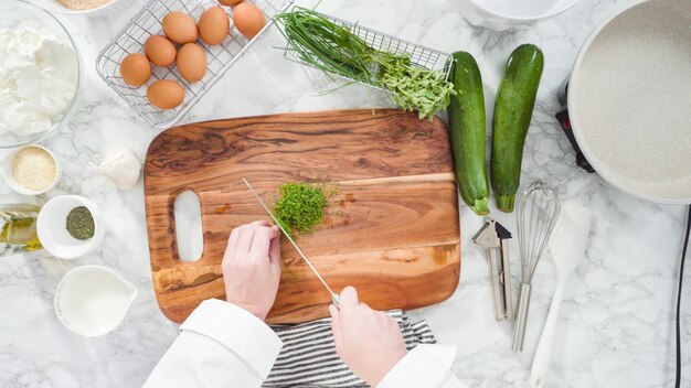 Plat leggen. stap voor stap. snij-ingrediënten voor het maken van courgettecakes met kruidenzure room.