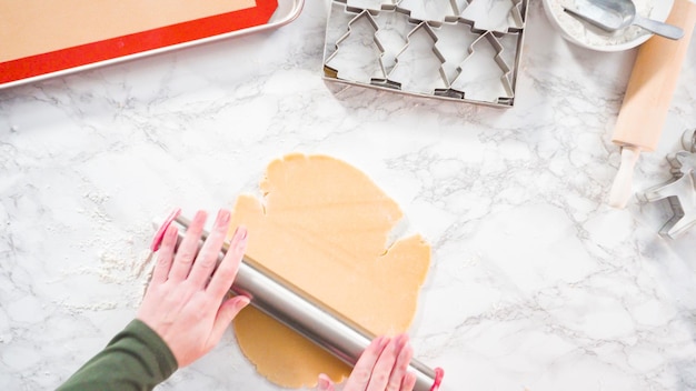 Plat leggen. Stap voor stap. Suikerkoekdeeg uitrollen om kerstkoekjes te bakken.