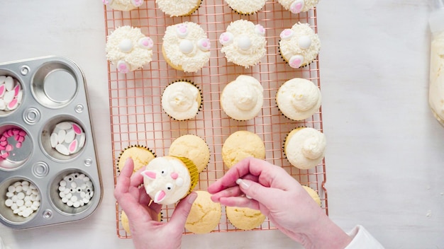 Plat leggen. Stap voor stap. Vanille cupcakes versieren met witte botercrème glazuur voor Pasen.