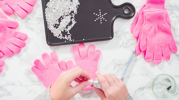 Plat leggen. Strass roze kinderhandschoenen met sneeuwvlokvormen.