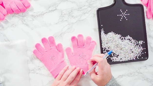 Plat leggen. Strass roze kinderhandschoenen met sneeuwvlokvormen.