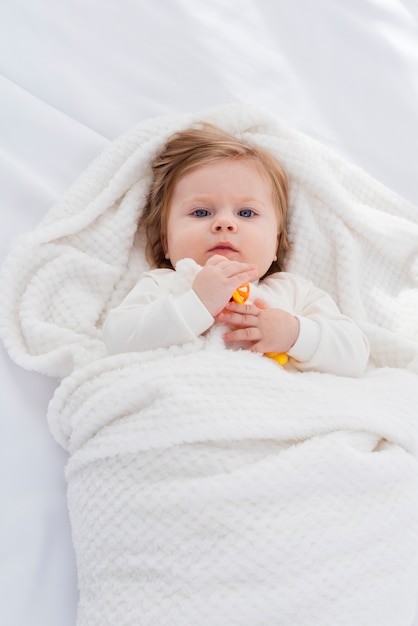 Plat leggen van baby in witte deken
