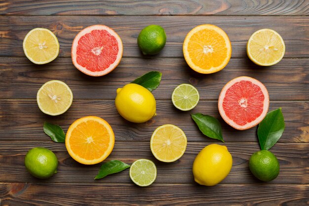 Plat leggen van citrusvruchten zoals limoensinaasappel en citroen met citroenboombladeren op lichtgekleurde achtergrond Ruimte voor tekst gezond concept Bovenaanzicht