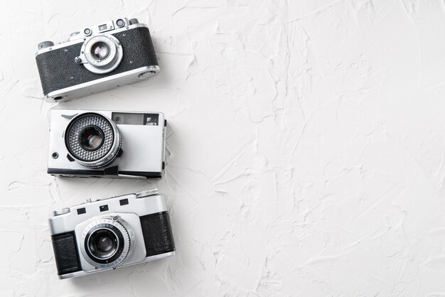 Plat leggen van drie oude vintage fotocamera's op de witte achtergrond met vrije ruimte voor tekstmodel