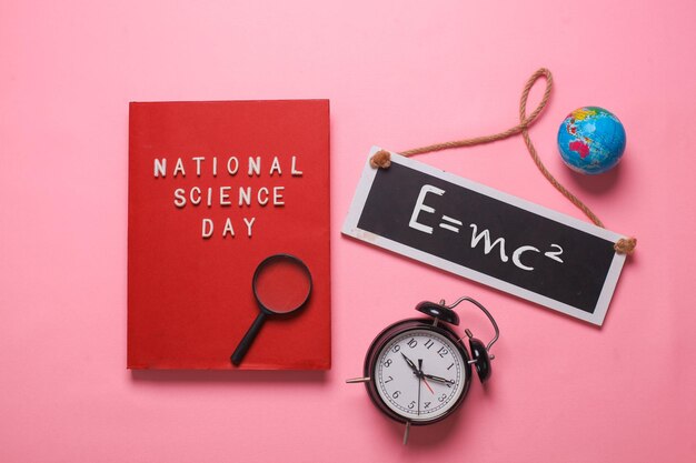 Plat leggen van National Science Day schrijven op rood boek met einsten-formule op uithangbord