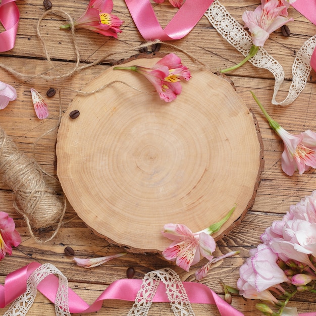 Plat leggen van roze bloemen en houten plank met kopieerruimte op houten tafel. mooie peruaanse lelies lay-out met ruimte voor sjabloon. romantisch concept voor vakantieviering