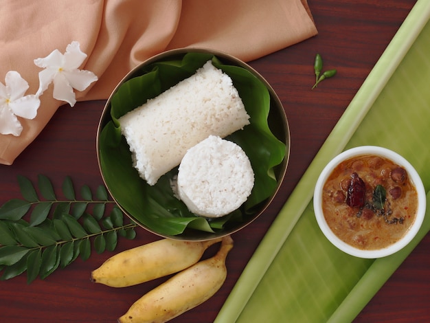 Plat leggen van traditionele Indiase ontbijt witte gestoomde puttu met curry en bananen