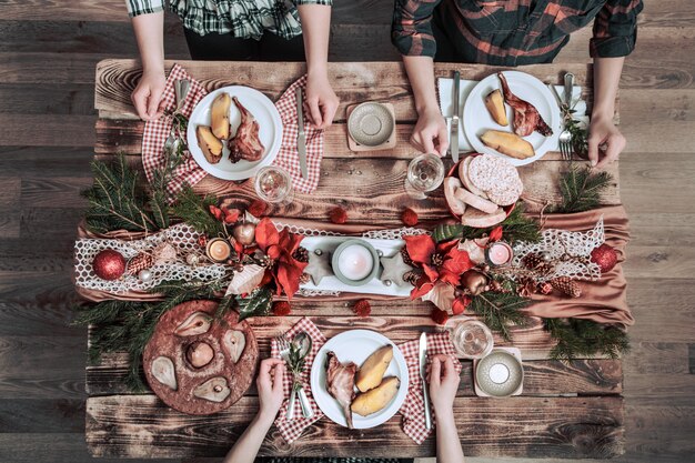 Plat leggen van vriendenhanden die samen eten en drinken. Bovenaanzicht van mensen die partij hebben, verzamelen, vieren samen aan houten rustieke tafel