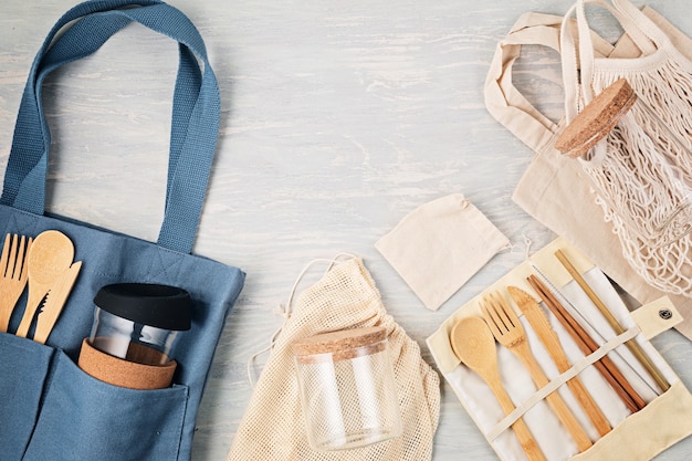 Plat leggen van Zero waste kit. Set van eco-vriendelijk bamboe bestek, net katoenen tas, herbruikbare koffieglas, borstels en waterfles. Duurzame, ethische, plasticvrije levensstijl. Bovenaanzicht