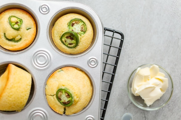 Plat leggen. Vers gebakken cornbread muffins met pittige jalapeno peper in muffin pan.