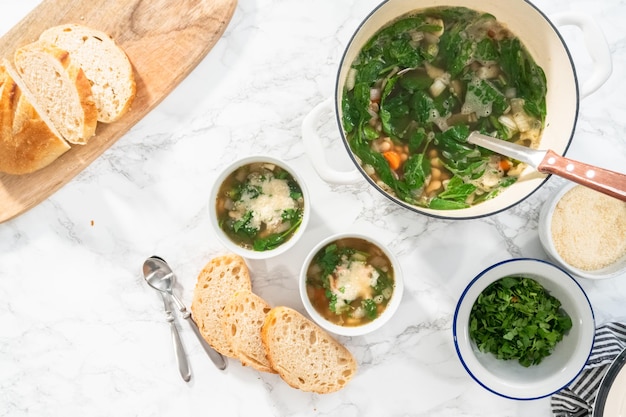 Plat leggen. Vers gekookte vegetarische witte bonensoep in een witte kom.