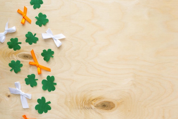 Plat leggen voor Saint Patricks Day Papieren klaverblaadjes met strikken op houten achtergrond