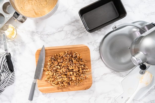 Plat leggen. walnoten in kleine stukjes hakken met keukenmes op een houten snijplank.