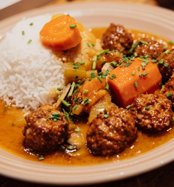 Foto plat van gehaktballen met rijst en wortels in saus