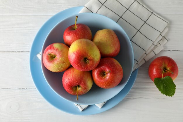  plate and apples on white wooden table