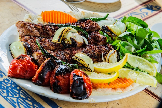 Plate of Arabic oriental barbeque, made of different kinds of meat,backed with vegetables