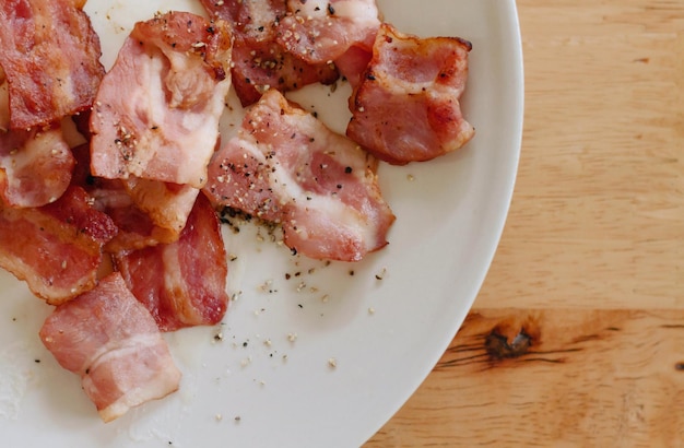 A plate of bacon on a wooden table