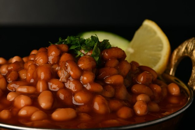 Photo a plate of baked beans with a lemon wedge on the side