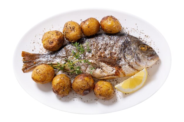 Plate of baked fish with potato isolated on white background