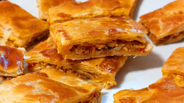 A plate of baklava with a slice cut out of it