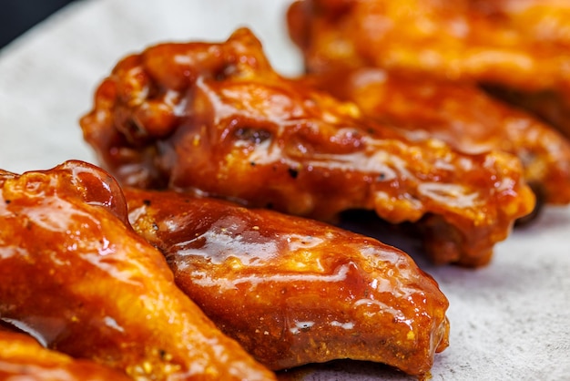 Photo plate of barbecue chicken wings on black background