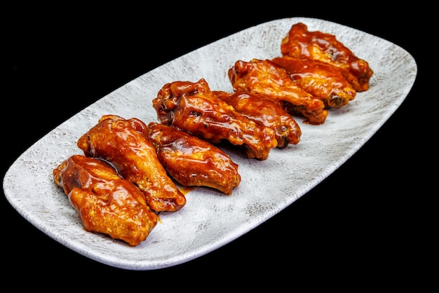 Photo plate of barbecue chicken wings on black background