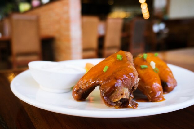 Plate of barbecue chicken wings in restaurant selective focus.