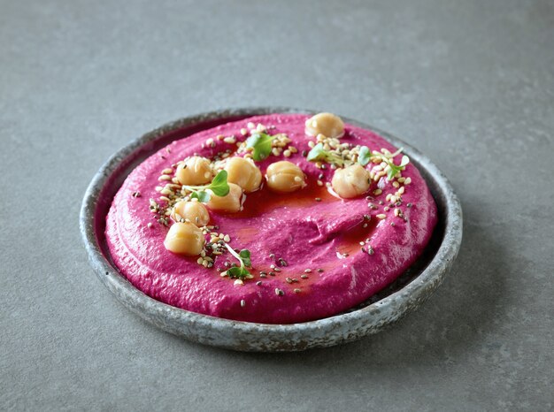 Plate of beetroot hummus on grey kitchen table