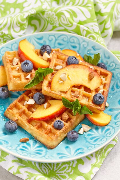 A plate of Belgian waffles with fresh fruits