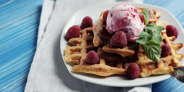 Plate of belgian waffles with ice cream and fresh berries