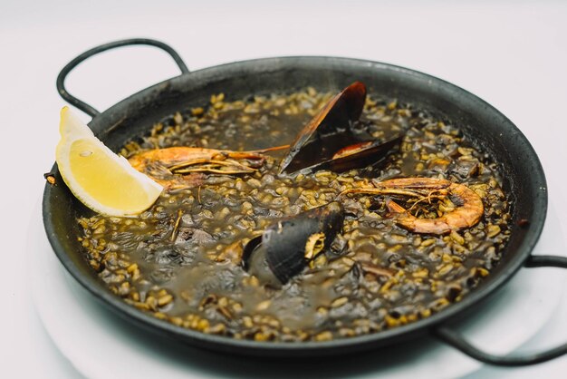 A plate of black rice paella with squid shrimp and mussels