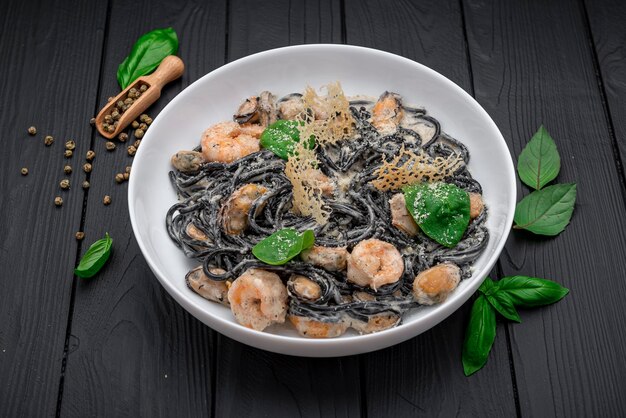 Тарелка черных спагетти с креветками и мидиями