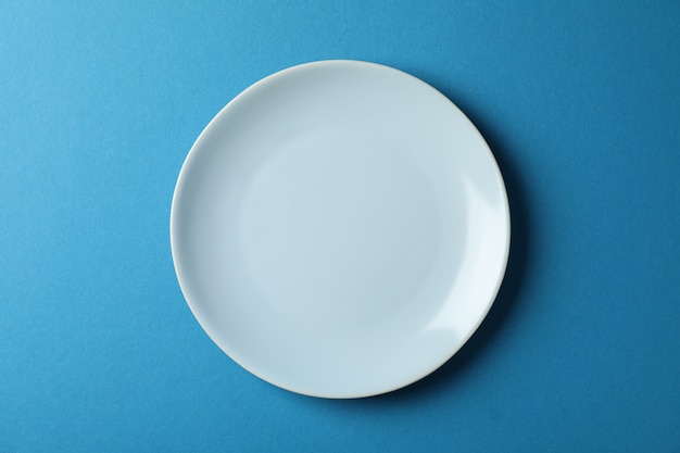 Plate on blue, top view and space for text