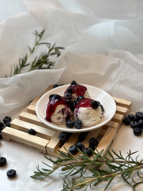 Foto un piatto di gelato di mirtilli con mirtilli sopra.