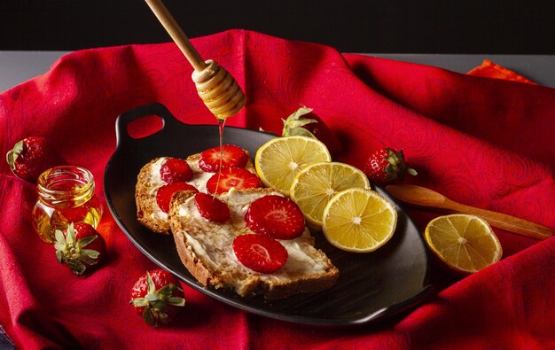 A plate of bread with lemons and strawberries on it