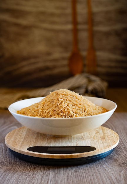 Photo plate of brown rice on scales in old kitchen setting