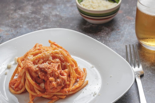 Foto un piatto di bucatini all'amatriciana con formaggio scamorza affumicato