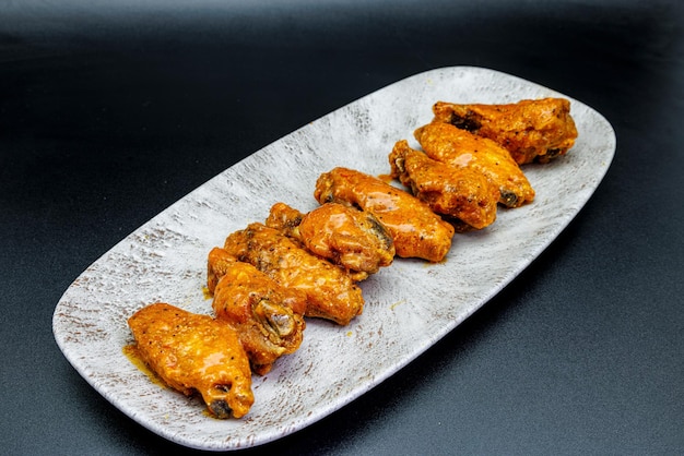 Photo plate of buffalo chicken wings on a black background