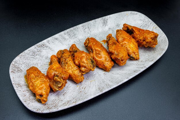 Plate of Buffalo chicken wings on a black background