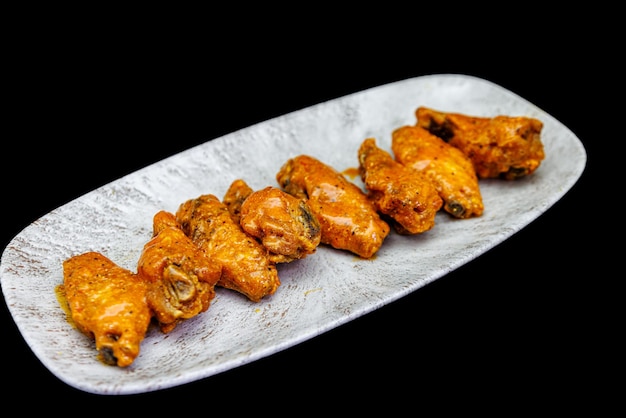 Photo plate of buffalo chicken wings on a black background