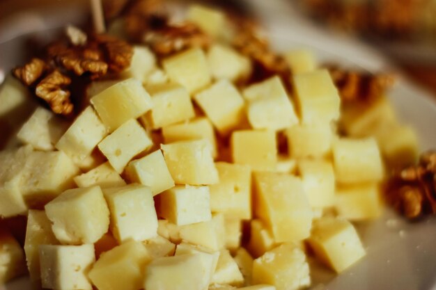 Photo a plate of cheese and walnut two types of cheese on a board closeup