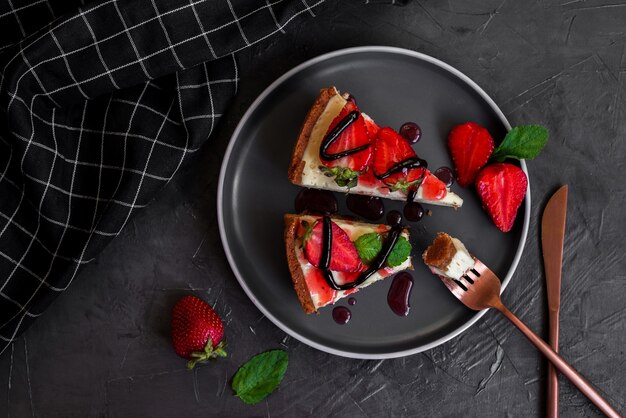 Foto un piatto di cheesecake con una salsa di fragole e cioccolato.