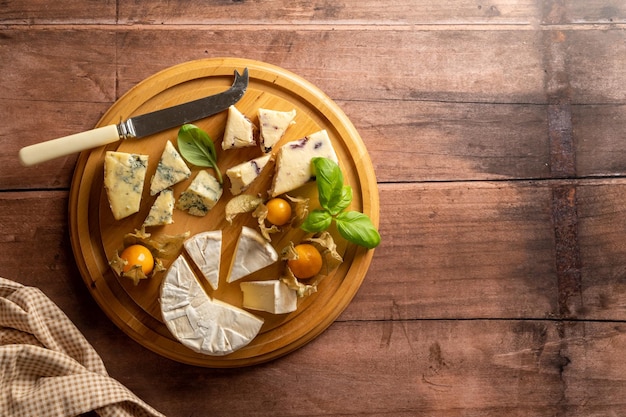 A plate of cheeses with a knife and a knife on top