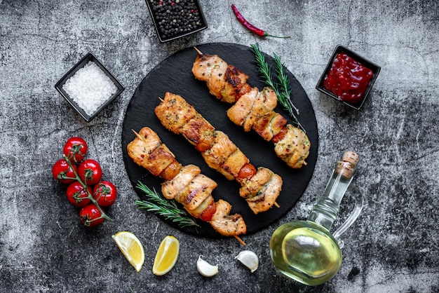 A plate of chicken skewers with olive oil and lemon slices on the side.