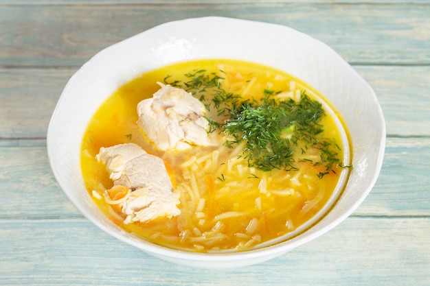 Photo plate of chicken soup on wooden table